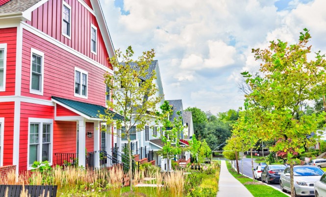 Colorful multicolored red, blue painted residential new townhouses, homes, houses in Maryland with cars on street in summer