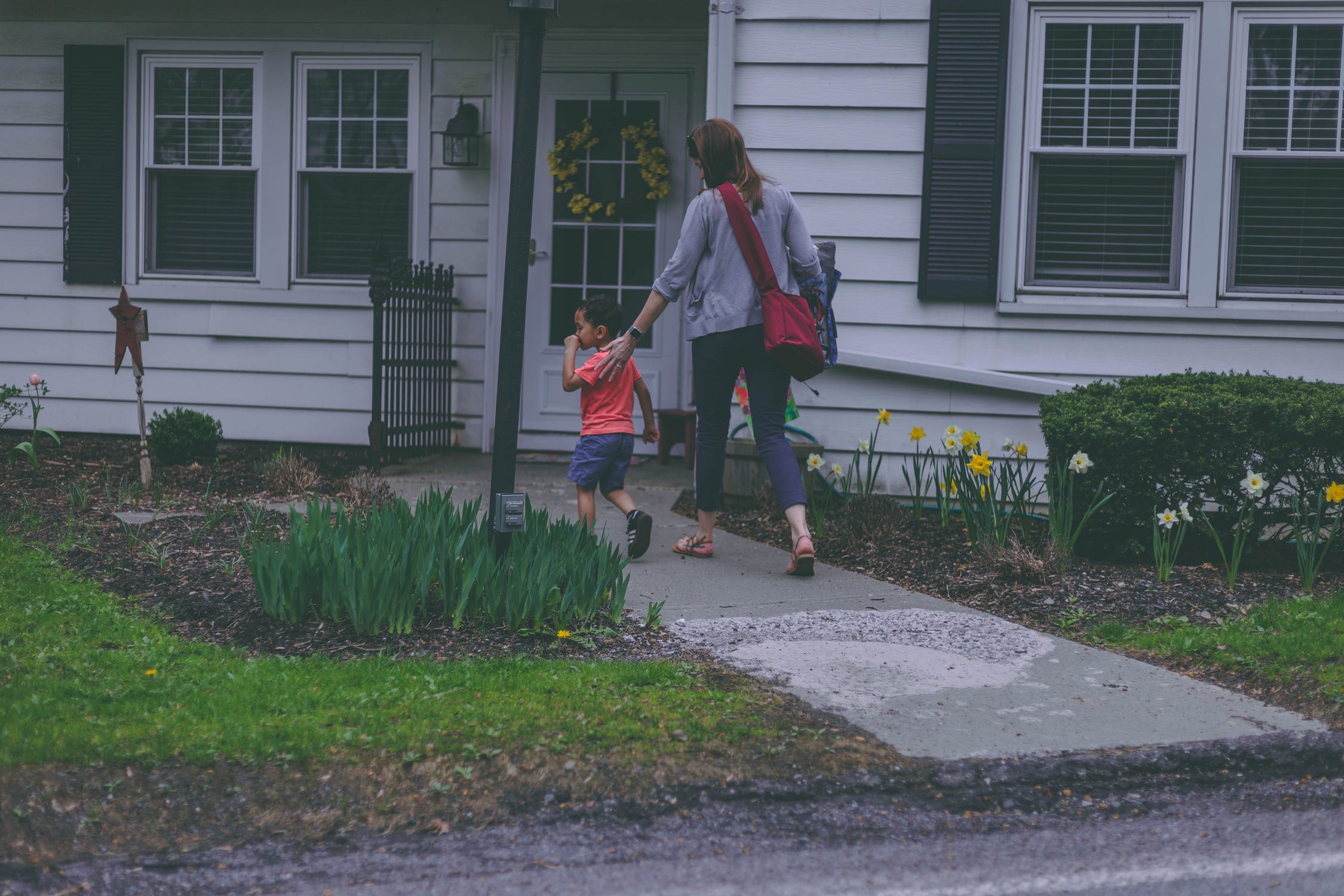 woman and boy in front of house